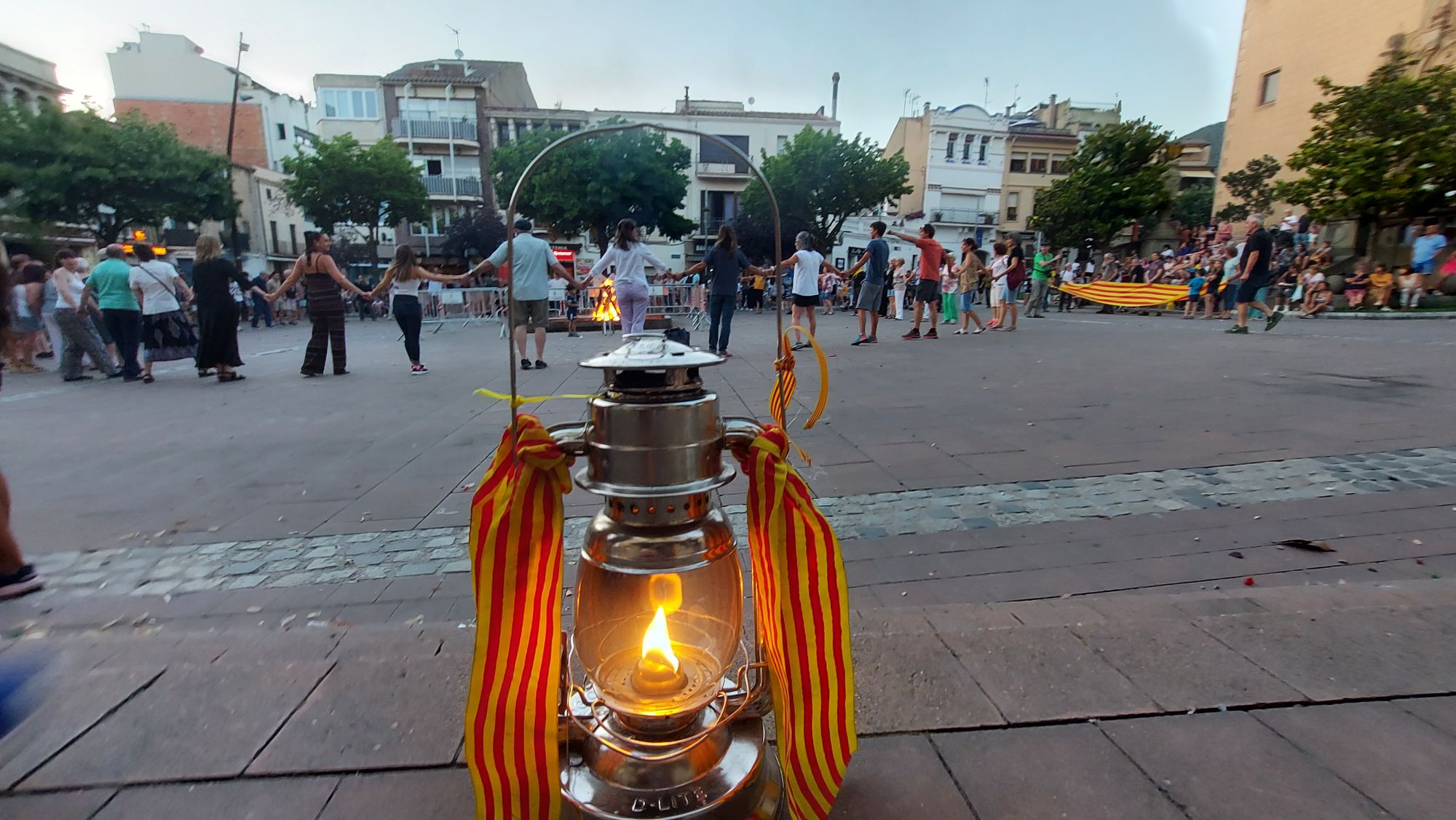Disfrutando de la Llama del Canigó en círculo, en la plaza de la Iglesia